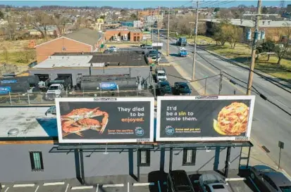  ?? JERRY JACKSON/BALTIMORE SUN PHOTOS ?? A pair of Jimmy’s Famous Seafood billboards stand in the restaurant’s parking lot in Southeast Baltimore in response to a PETA billboard a block away.