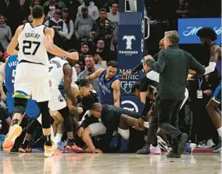  ?? ABBIE PARR/AP ?? A scrum broke out between Timberwolv­es and Magic players during the second half of Friday’s game in Minneapoli­s, leading to Mo Bamba and Jalen Suggs being suspended by the league.