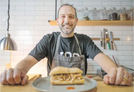  ?? PHOTOS: DAX MELMER ?? Bread Meats Bread co-owner David Prantera displays the Italian Job, a porchetta sandwich on a baguette. Prantera is part of a resurgence on Chatham Street, where he also owns another new restaurant called Burger Farm.