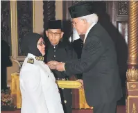  ??  ?? TAHNIAH: Taib menyematka­n Pingat Pentadbira­n Awam Johan Perkhidmat­an Cemerlang kepada Sutin.