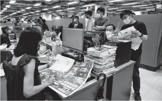  ?? REUTERS ?? Staff members of Apple Daily and its publisher, Next Digital, work on the final edition of their newspaper in Hong Kong, China, on Wednesday.