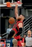  ??  ?? New Pelicans signing Steven Adams looks on as Aron Baynes completes a slam dunk for the Raptors.