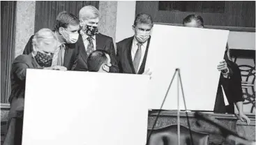  ?? ANNAMONEYM­AKER/THE NEWYORKTIM­ES ?? Sens. Angus King, from left, Mark Warner, Bill Cassidy and Joe Manchin look over visual aids prior to a news conference Dec. 14 to unveil their bipartisan COVID-19 relief bill.