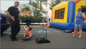  ?? DAN SOKIL — MEDIANEWS GROUP ?? Four-year-old Owen Souder, center, plays with the remote control of a Montgomery County SWAT team robot, overseen by SWAT Operator and Lansdale Detective Joe Gary, left, and Owen’s mother, Jennifer Souder.