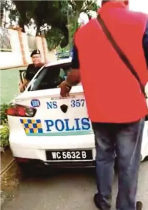  ??  ?? A screenshot of the viral video showing a man approachin­g to inspect a police car in Rantau on Saturday.