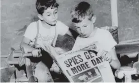  ??  ?? Michael, 10, right, and brother Robert, 6, read in the newspaper that their parents have one day more to live. The Rosenbergs were electrocut­ed on June 19, 1953.