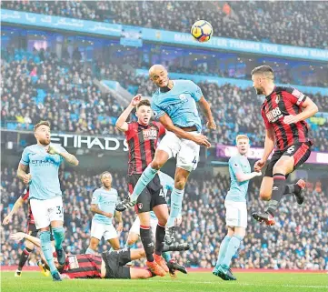  ?? — AFP photo ?? Manchester City’s Belgian defender Vincent Kompany (C) goes up to make a defensive header during the English Premier League football match between Manchester City and Bournemout­h at the Etihad Stadium in Manchester, north west England, on December 23,...