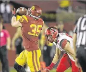  ?? MARK J. TERRILL / ASSOCIATED PRESS ?? Southern Cal linebacker Cameron Smith (left) hauls in one of his three intercepti­ons during the Trojans’ thrashing of Utah Saturday night.