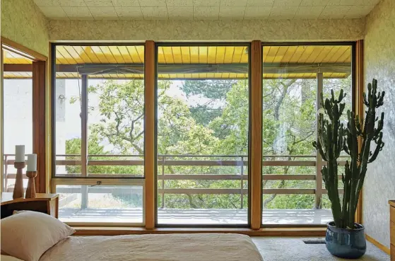  ??  ?? SIMPLE LINES AND LARGE WINDOWS SEAMLESSLY COMBINE TO GIVE THIS BEDROOM A BEAUTIFUL VIEW AS WELL AS WONDERFUL NATURAL LIGHTING. THE VIEW GIVEN BY THESE WINDOWS, AS WELL AS THE LARGE INDOOR CACTUS, WORK TO BLUR THE LINES BETWEEN WHAT IS MANMADE AND WHAT...