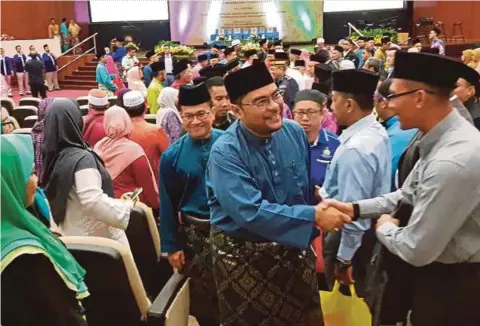  ?? PIC FROM MUJAHID’S FACEBOOK PAGE ?? Minister in the Prime Minister’s Department Datuk Dr Mujahid Yusof Rawa (centre) being greeted by guests at a Maal Hijrah 1440H celebratio­n in Kuala Lumpur on Thursday.