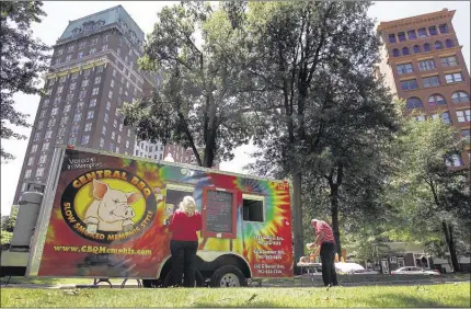  ?? PHOTOS BY MARK WEBER/THE COMMERCIAL APPEAL ?? Customers get their fix of pulled pork sandwiches and other favorites at Court Square from about 11 a.m. to 2 p.m. every Thursday, when a variety of food trucks gather at the Downtown park. Other places to find mobile meals include Levitt Shell...