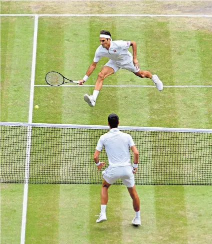  ??  ?? Close battle: Roger Federer stretches for a shot after being drawn to the net by Novak Djokovic in their stunning final