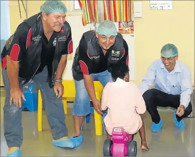  ?? Picture: BRIAN WITBOOI ?? STRONG SUPPORT: Andre Potgieter, left, and Chris Black, both of the Wildhorse Motorcycle Club, together with Dr Aydin Vehbi, of the burns unit at Dora Nginza Hospital, play with one of the patients