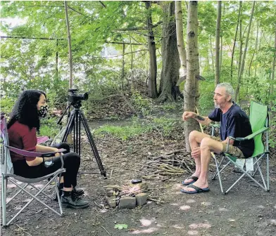  ?? ERIC WYNNE • THE CHRONICLE HERALD ?? Multimedia journalist Noushin Ziafati interviews Allan Deyoung outside his ‘home’ in Dartmouth. He says he won’t leave his “temporary housing” in a green space near Alderney Landing. The almost 60-year-old man has been bouncing when it comes to housing after he lost his job at the beginning of the pandemic early last year.