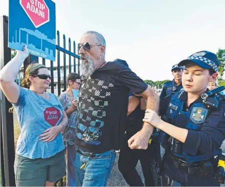  ?? Picture: ZAK SIMMONDS ?? SCUFFLE: A man is led away by police after clashing with protesters outside the meeting.