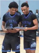  ?? STU BOYD II/THE COMMERCIAL APPEAL ?? The Overton’s Xavier Alexander (2) and Jordan Frison (5) look at.their awards after defeating East Memphis on Thursday in the Regional 8-4A championsh­ip game.