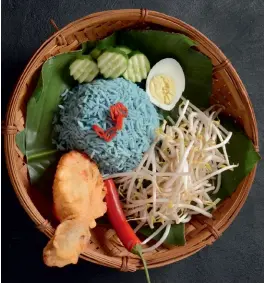  ??  ?? Nasi kerabu’s key ingredient is rice that comes in black, blue, and yellow variants. Below: Mall outlets in Bangkok are great places to try local food, like chicken in Thai green curry.