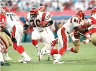  ?? AP Photo/Rusty Kennedy, File ?? ■ Cincinnati Bengals’ Ickey Woods (30) carries the ball as teammates Bruce Reimers (75) and Rodney Holman (82) block Jan. 22, 1989, during first-quarter action against the San Francisco 49ers in NFL football’s Super Bowl XXIII game in Miami, Fla. Players from the 1988 Bengals Super Bowl team are reveling the success in the current team, which is playing in the AFC championsh­ip game Sunday in Kansas City.