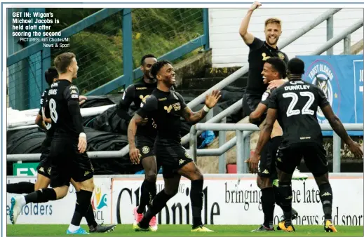  ?? PICTURES: Ian Charles/MI News & Sport ?? GET IN: Wigan’s Michael Jacobs is held aloft after scoring the second