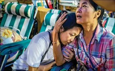  ?? LINH PHAM / GETTY IMAGES ?? Relatives react Monday after the 12 boys and their soccer coach were found alive in the cave where they were missing for over a week after monsoon rains blocked the main entrance in Chiang Rai, Thailand.