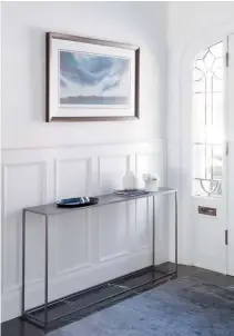  ??  ?? RIGHT With the old vestibule enclosure removed, the front entry feels airy. Contempora­ry pieces, such as the console, let the historic architectu­re shine. CONSOLE, CB2; RUG, Elte; PRINT, Ron Eady.