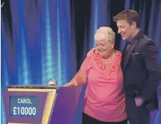  ??  ?? Carol Kelly celebrates her win with Tipping Point host Ben Shephard.