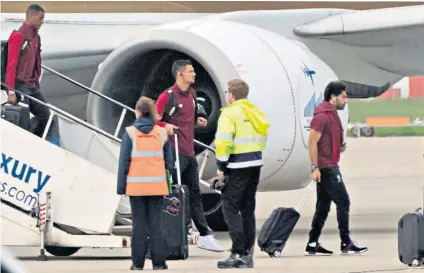  ??  ?? The morning after: Mohamed Salah walks off the plane after touching down in Liverpool following his miserable evening