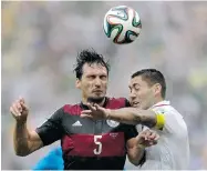  ?? JULIO CORTEZ/ THE ASSOCIATED PRESS ?? Germany’s Mats Hummels clashes with the U.S.’s Clint Dempsey on Thursday in Recife, Brazil. Germany won 1-0.