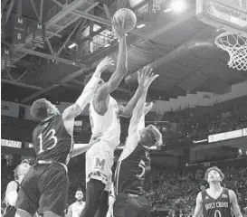  ?? KEVIN RICHARDSON/BALTIMORE SUN ?? Maryland’s Jalen Smith squeezes between Holy Cross defenders Marlon Hargis, left, and Connor Niego to get off a shot Tuesday night during the first half of the season opener.