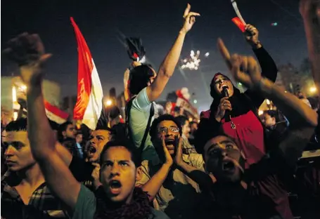  ?? MAHMUD KHALED/AGENCE FRANCE-PRESSE, GETTY IMAGES ?? Protesters call for the ouster of President Mohammed Morsi as they watch his address to the nation on a screen in a Cairo street on Wednesday.