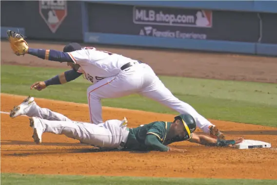  ?? Photos by Marcio Jose Sanchez / Associated Press ?? Houston first baseman Yuli Gurriel forces out Oakland’s Marcus Semien at first base after Tommy La Stella lined out for a double play during the third inning.