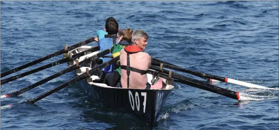  ??  ?? Micheál O’Leary glances over his shoulder to confirm he and his crew were on course for victory in the parish race at the Maharees Regatta on Sunday. Photo by Declan Malone