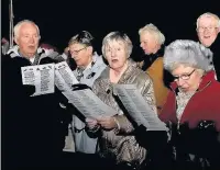  ??  ?? Carolling around the tree in Stanhill Village’s Memorial Gardens