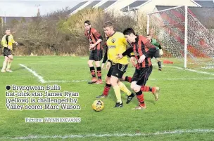  ?? Picture: WYNNE EVANS ?? Bryngwran Bulls hat-trick star James Ryan (yellow) is challenged by Valley scorer Marc Wilson