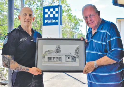  ?? ?? Queensland Police Service Senior Sergeant Geoff Bormann and retired superinten­dent Frederick Angus with a sketch of the old Ingham Police Station by Forrest Beach artist Barbara Saxton. Picture: Cameron Bates