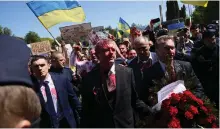  ?? EPA ?? Protesters said the paint thrown on Russian ambassador Siergiej Andriejew, centre, represente­d the blood spilt in Ukraine
