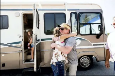  ?? NOAH BERGER — THE ASSOCIATED PRESS ?? Woody Faircloth hugs Sheri Roen as her family donates their motorhome to EmergencyR­V.org on Sept. 5, in Sierra County Accompanie­d by daughter Luna, left, Faircloth delivered it to a Dixie Fire victim later that day,