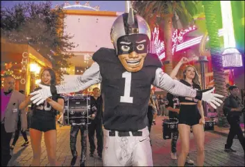  ?? Review-Journal file ?? Raider Rusher, the Raiders’ much-maligned mascot, celebrates with Diana Tatevossia­n, left and Kayla Kalisz of “Extreme Live Show” at a watch party at the Linq Promenade before the first game of the 2019 season against the Denver Broncos.