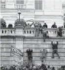  ?? Associated Press file photo ?? Trump loyalists scale the U.S. Capitol’s west wall on Jan. 6, 2021.