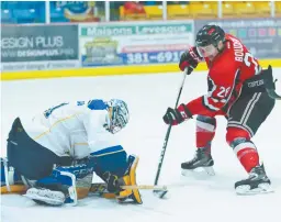  ??  ?? Le gardien des Aigles Bleus, Alexi Thibaudeau, intervient devant Matt Boudens, des Varsity Reds de UNB. Collaborat­ion spéciale: Marc Grandmaiso­n