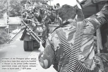  ??  ?? Members of the Philippine police special action force make their way to the frontline in Marawi as the armed conflict between government troops and Islamist militants enters its fourth week. — AFP photo