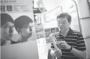  ?? — Gambar AFP ?? INSPIRASI: Roger Wong memegang buku yang diberinya kepada anaknya berjudul “People Will Not Forget”, satu susunan karangan ditulis oleh beberapa wartawan selepas kembali dari membuat liputan mengenai tindakan di Dataran Tiananmen di Beijing pada 1989,...
