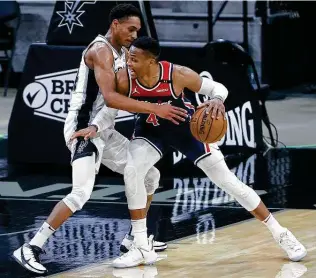  ?? Tom Pennington / Getty Images ?? Devin Vassell, defending the Wizards’ Russell Westbrook, became the first Spurs rookie with four or more 3-pointers in a game since Gary Neal in 2011, hitting 4 of 6 in Sunday’s victory.