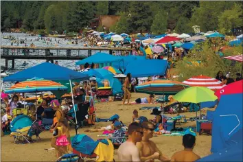  ?? PHOTO BY RAY CHAVEZ — STAFF ARCHIVES ?? Beachgoers cool off at Kings Beach State Recreation Area on Aug. 16. COVID-19 herd immunity may be difficult to reach, in part because of vaccine hesitancy, vaccines are not fully effective and new variants have emerged.