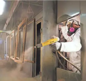  ?? JOE RONDONE/THE COMMERCIAL APPEAL ?? Tommy Marion paints lite kit window frames at National Guard Products, an 85-year-old privately held manufactur­er of commercial door hardware, in 2022.