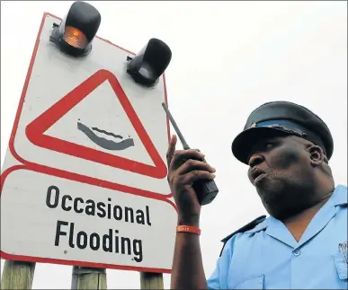  ?? Picture: FREDLIN ADRIAAN ?? CONTROL SYSTEM: An early warning system is activated by assistant superinten­dent Ginger Nangu at the 3rd Avenue dip in Newton Park yesterday. It will replace the current boom gates and bollards