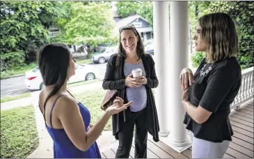  ?? CONTRIBUTE­D PHOTOS BY TAMIR KALIFA ?? Leah Frederick (left) and Janae Dunn (far right), the owners of Stork Maternity Consulting, greet Tracy Herzik as she arrives for a centering session on comfort measures during childbirth.
