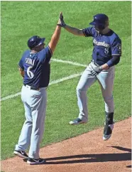  ?? GETTY IMAGES ?? Ryan Braun (right) is congratula­ted by Ed Sedar after hitting the go-ahead home run against St. Louis on Saturday.