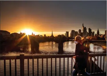  ?? (AP/Michael Probst) ?? A man crosses a bridge earlier this week in Frankfurt, Germany. The European economy rebounded in the July-September quarter after a sharp downturn in the April-June period because of coronaviru­s lockdowns.