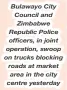  ?? ?? Bulawayo City Council and Zimbabwe Republic Police officers, in joint operation, swoop on trucks blocking roads at market area in the city centre yesterday